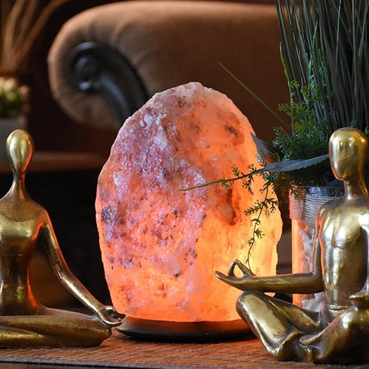 Hand-carved pink Himalayan salt lamp glowing on a wooden base
